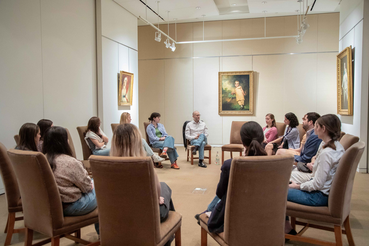 Room full of people in chairs in an art space